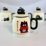 ماگ سرامیکی درب‌دار طرح “گربه سیاه” (I Love You Cat) قاشق استیل و عروسک روی درب - تصویر 3